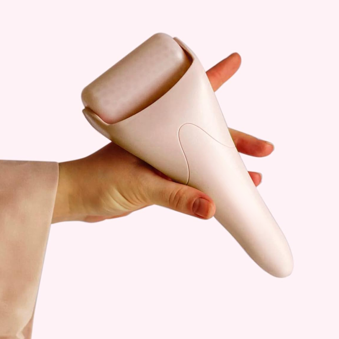 Hand hält rosa Gesichts-Eisroller, Hautpflegegerät, Wellness-Tool, glatter Hintergrund.