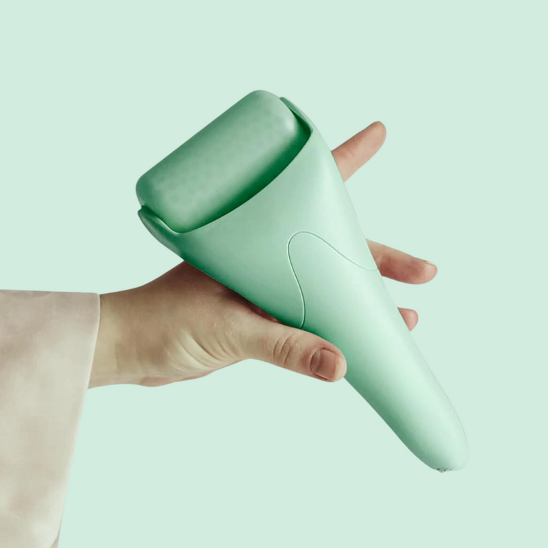 Hand hält mintgrünen Gesichts-Eisroller, Hautpflegegerät, Wellness-Tool.