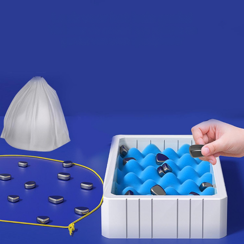 Hand greift nach magnetischen Steinen in blauer Aufbewahrungsbox, weißer Hintergrund.