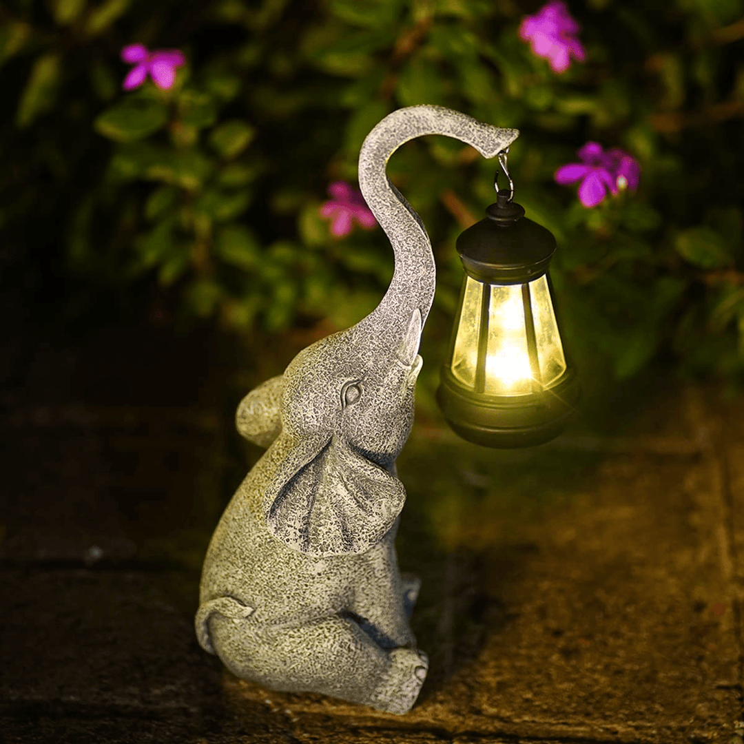 Stein-Elefant mit Laterne, Garten-Dekoration, beleuchtet, Nacht, Blumen im Hintergrund