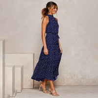 Frau in eleganter, langärmeliger, gepunkteter blauer Kleid, High Heels, stilvoll, modisch.