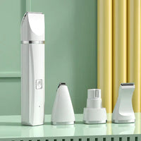 Weißer elektrischer Haarschneider mit drei Aufsätzen auf grünem Hintergrund.