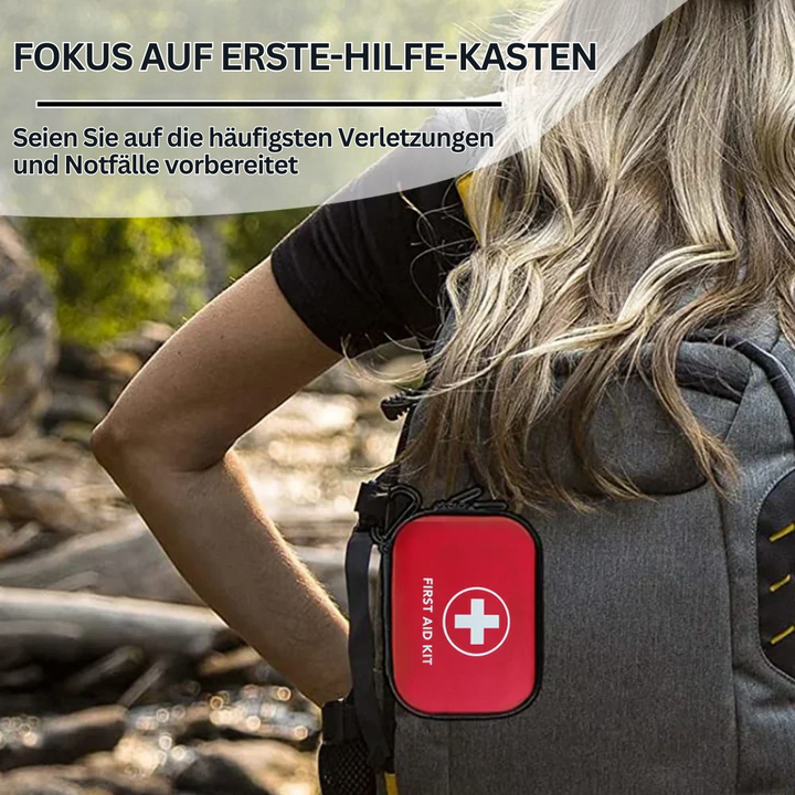 Rotes Erste-Hilfe-Set am grauen Rucksack, Outdoor-Notfallausrüstung, kompakt und tragbar.