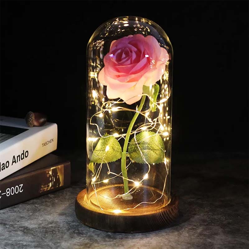 Glasdom mit rosa ewiger Rose und LED-Lichtern auf Holzsockel, dekorative Beleuchtung.