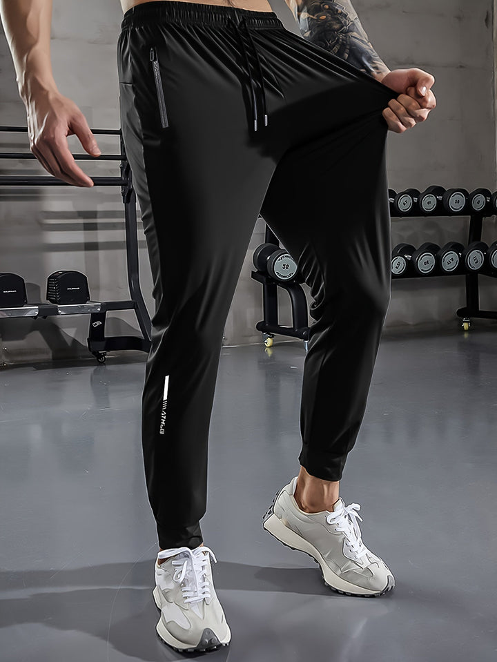 Schwarze Herren-Trainingshose, elastisch, mit Reißverschlusstaschen, im Fitnessstudio.