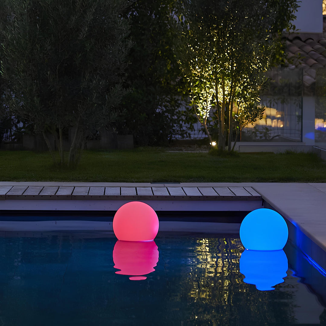 Leuchtende LED-Poolkugeln, rosa und blau, schwimmend im Wasser, Gartenbeleuchtung