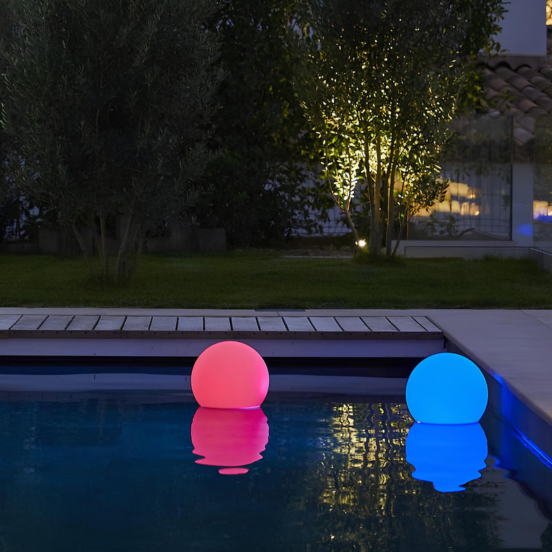 Leuchtende LED-Poolkugeln, rosa und blau, schwimmend im Wasser, Gartenbeleuchtung