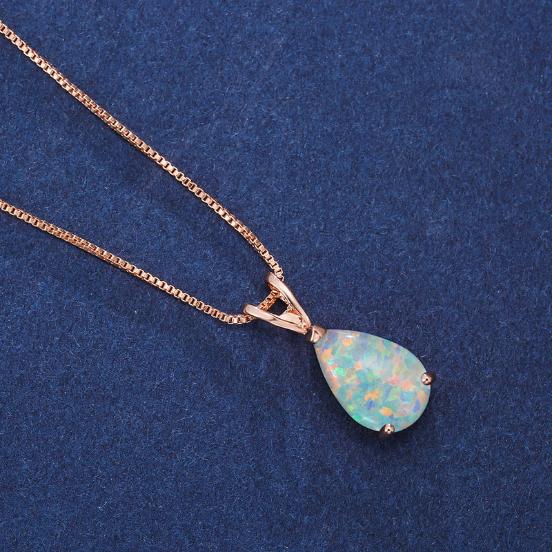 Opal-Anhänger mit Roségoldkette auf blauem Hintergrund, eleganter Schmuck für Damen.