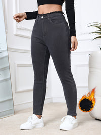 Frau in schwarzer High-Waist-Jeans und weißem Sneaker, modisch, bequem, Alltagskleidung.