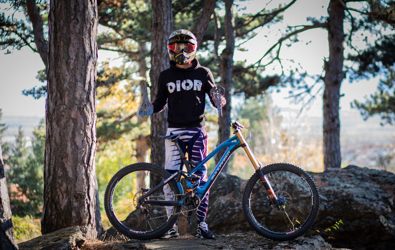Mountainbiker mit blauem Fahrrad und Helm im Wald, Outdoor-Abenteuer, Fahrradfahren.