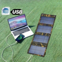 Wasserdichtes USB-Solar-Ladegerät auf Rasen neben Laptop und Smartphone.