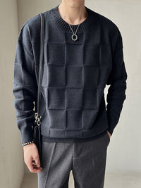 Mann in schwarzem Strickpullover mit Karomuster, graue Hose, modisches Outfit, Herrenmode.