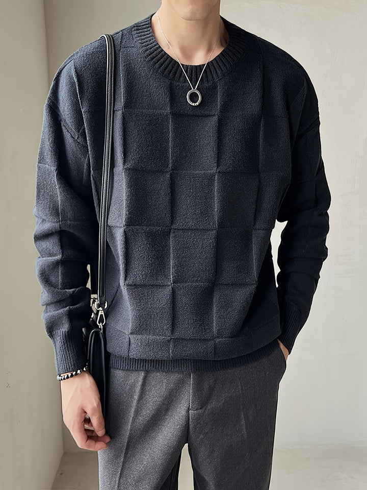 Mann in schwarzem Strickpullover mit Karomuster, graue Hose, modisches Outfit, Herrenmode.