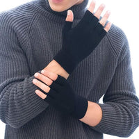 Mann mit grauem Strickpullover trägt schwarze fingerlose Handschuhe aus Wolle.