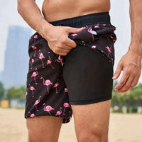 Mann in Flamingo-Badeshorts, schwarz-rosa, am Strand, Sommermode, Herrenbekleidung.