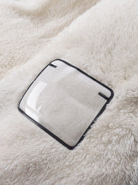 Weiße flauschige Decke mit transparentem Kunststofffenster, gemütlich, weich, Heimtextilien.