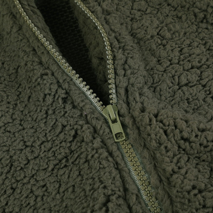 Grüner Fleece-Reißverschluss, weiches Material, Outdoor-Bekleidung, warm, kuschelig, Detailansicht.