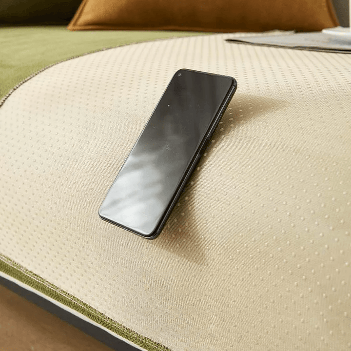 Smartphone auf beiger Anti-Rutsch-Fleecedecke auf Sofa, modernes Wohnzimmer-Design.