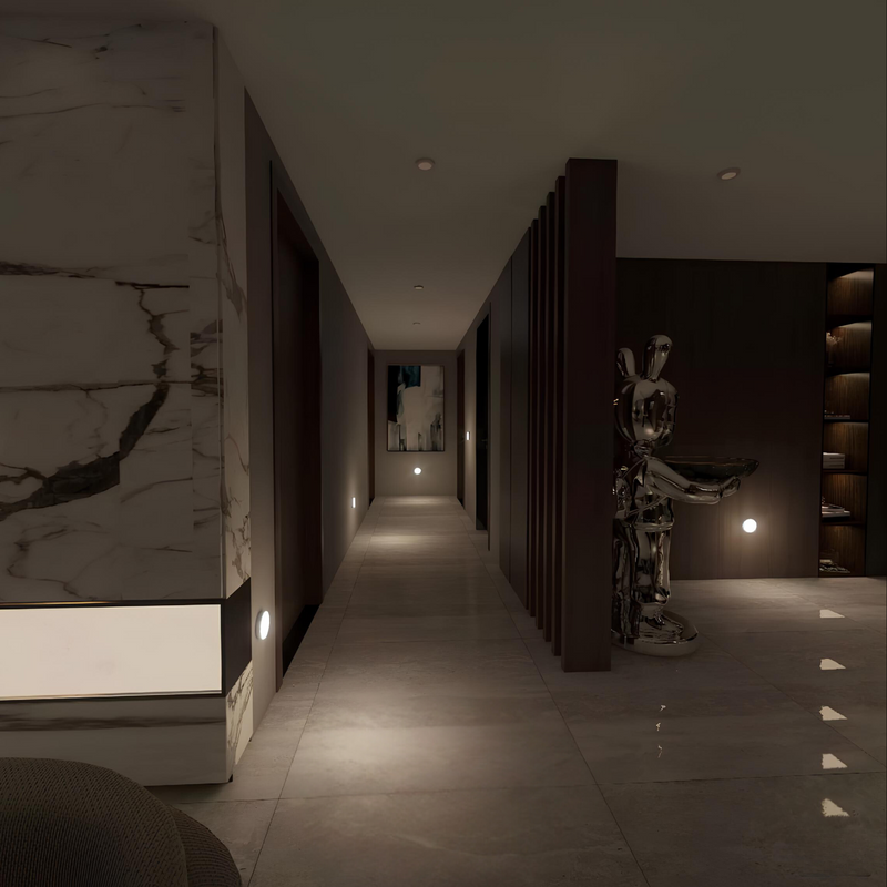 Moderner Flur mit Marmordekor, Skulptur und stimmungsvoller Beleuchtung.