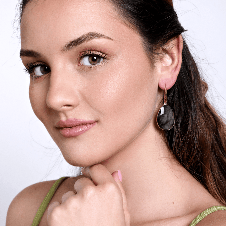 Frau mit schwarzem Ohrring, Nahaufnahme, Modeaccessoire, elegantes Design, Schmucktrends.