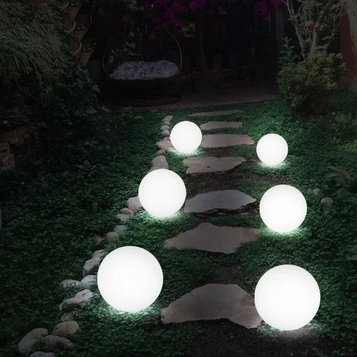 Leuchtende Gartenkugeln auf Steinweg, LED-Solarleuchten, Außenbeleuchtung, Nachtaufnahme