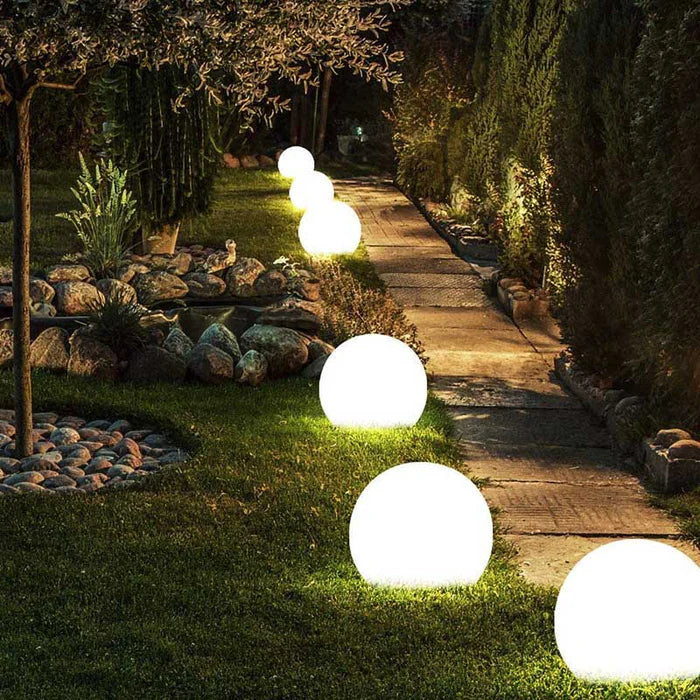 Leuchtende Gartenkugeln entlang eines Gehwegs, LED, weiß, dekorative Außenbeleuchtung.