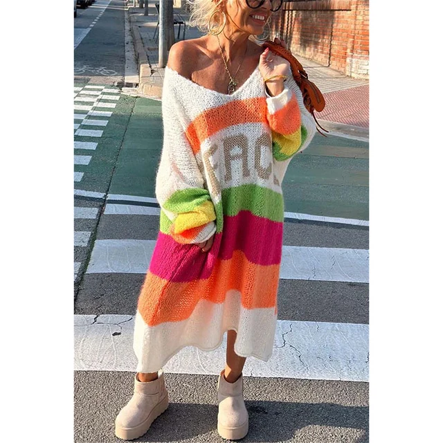 Frau trägt bunten Strickcardigan mit Regenbogenstreifen auf der Straße.