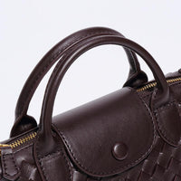 Dunkelbraune geflochtene Lederhandtasche mit Griffen, elegante Damenmode Accessoire.