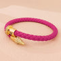 Rosa geflochtenes Lederarmband mit goldener Verschlusskappe, modisches Accessoire.
