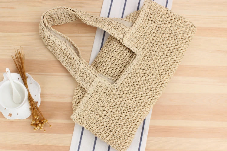 Beige handgefertigte Stricktasche aus Baumwolle auf Holztisch, umweltfreundliche Mode.