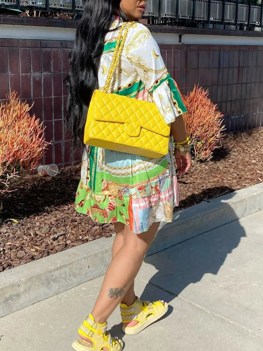 Frau mit gelber Designer-Handtasche, Sommerkleid und Sandalen, modisch, urbaner Stil.