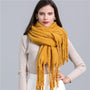 Frau mit gelbem Wollschal, modisch, warm, Herbst-Winter-Accessoire, elegantes Design.