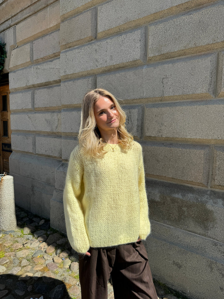 Frau in gelbem Strickpullover, lässige Mode, Herbstoutfit, blonde Haare, Stadtmauer.