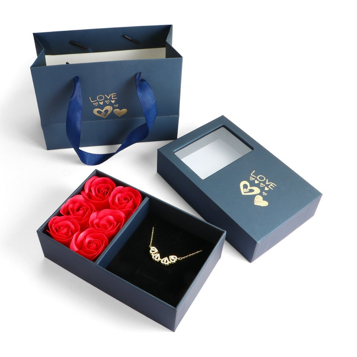 Blaue Geschenkbox mit roten Rosen und goldener Halskette, ideal für romantische Anlässe.