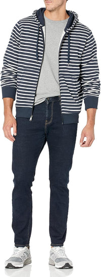 Mann in gestreifter Kapuzenjacke, grauem T-Shirt, dunklen Jeans und Sneakers.