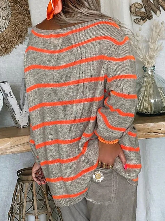 Frau in gestreiftem Pullover, beige mit orange Streifen, lässiger Herbstlook, Rückansicht.