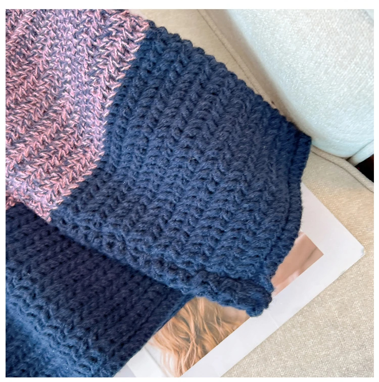 Gehäkelte Decke in Blau und Rosa auf beigem Sofa, handgemacht, gemütlich, Wohnaccessoire.