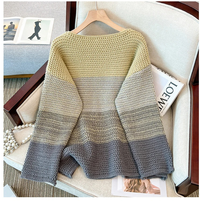 Gestrickter Pullover in Gelb und Grau, Damenmode, gemütlich, auf Sessel drapiert.