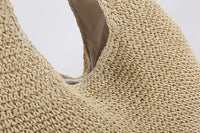 Beigefarbene, handgewebte Strohtasche, Nahaufnahme, umweltfreundliche Modeaccessoires.