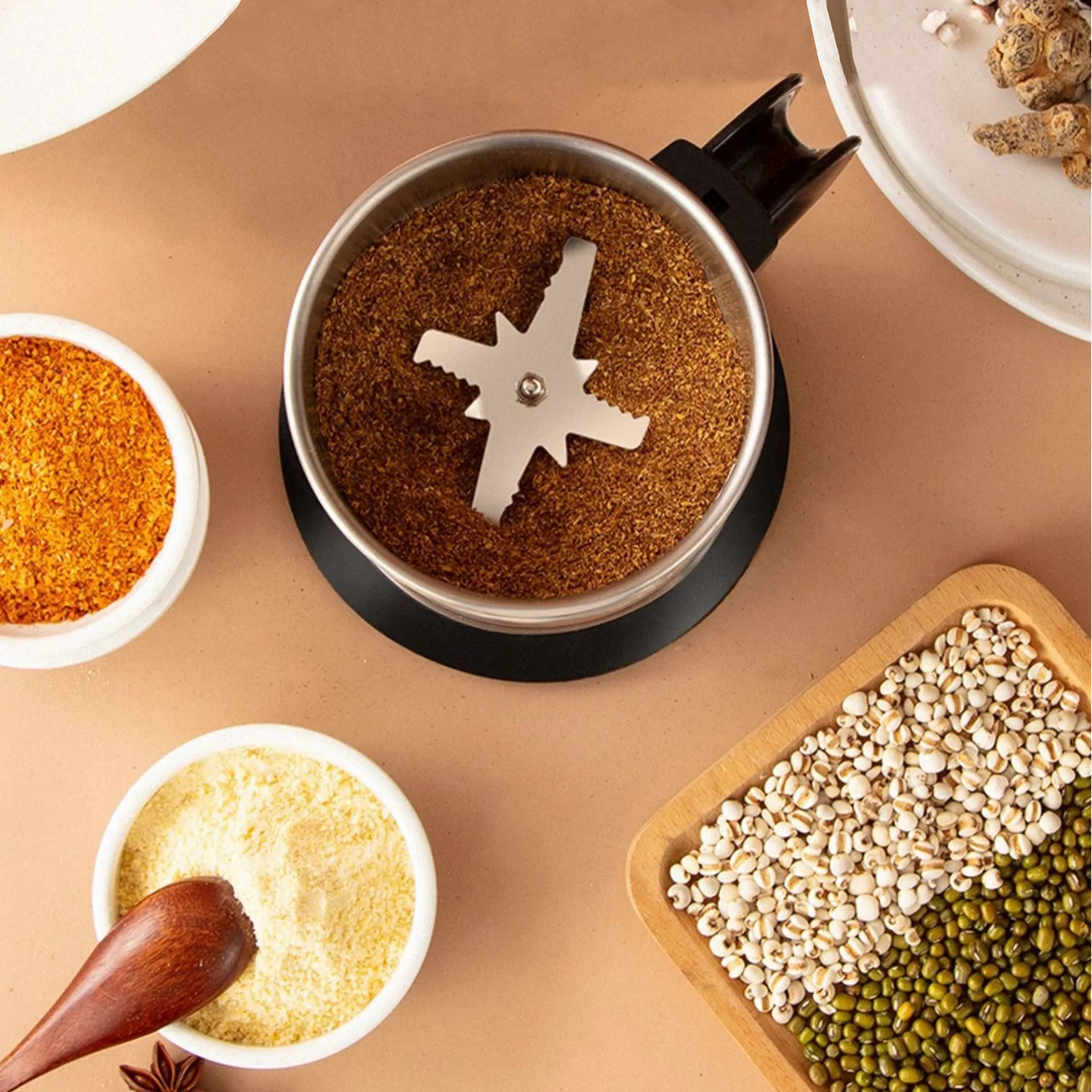 Elektrische Gewürzmühle aus Edelstahl mit gemahlenen Gewürzen, ideal für Küchenzubehör.