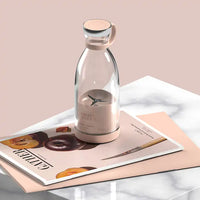 Transparente Glasflasche mit rosa Deckel auf Magazin, stilvolles Küchendesign.