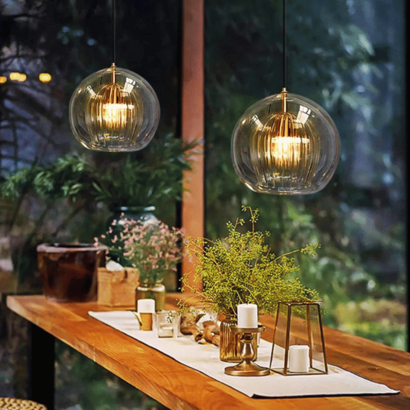 Zwei hängende Glaspendelleuchten über Holztisch, moderne Innenbeleuchtung, Wohnzimmerdekor.