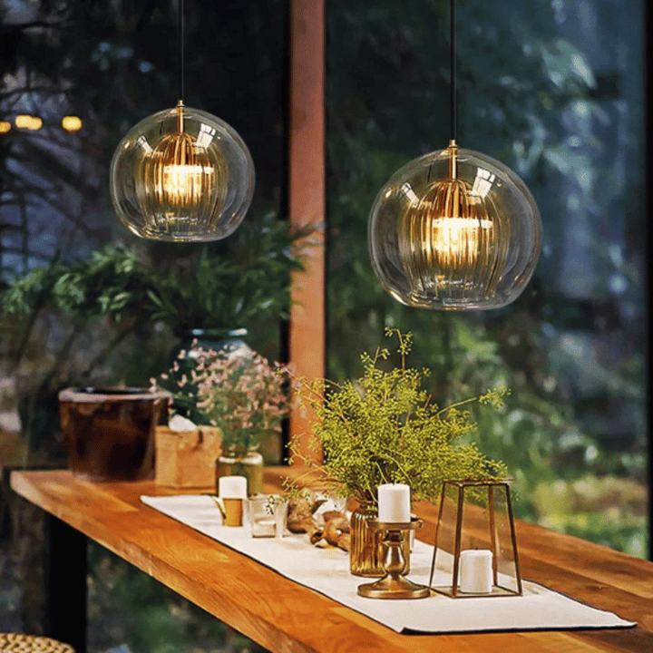 Zwei hängende Glaspendelleuchten über Holztisch, moderne Innenbeleuchtung, Wohnzimmerdekor.