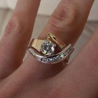 Goldener und silberner Verlobungsring mit Diamanten auf Finger, elegantes Schmuckdesign.