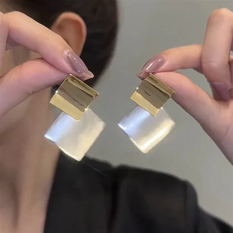 Goldene und silberne geometrische Ohrringe, modern, elegant, Damenmode-Accessoire.