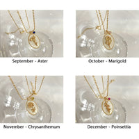 Goldene Halsketten mit Blumenanhänger für September, Oktober, November, Dezember auf Glasdisplay.