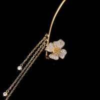 Goldene Blumen-Haarnadel mit Strasssteinen und Ketten, elegantes Schmuckaccessoire.