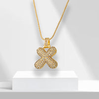 Goldene Halskette mit X-Anhänger, besetzt mit Diamanten, luxuriöses Schmuckdesign.