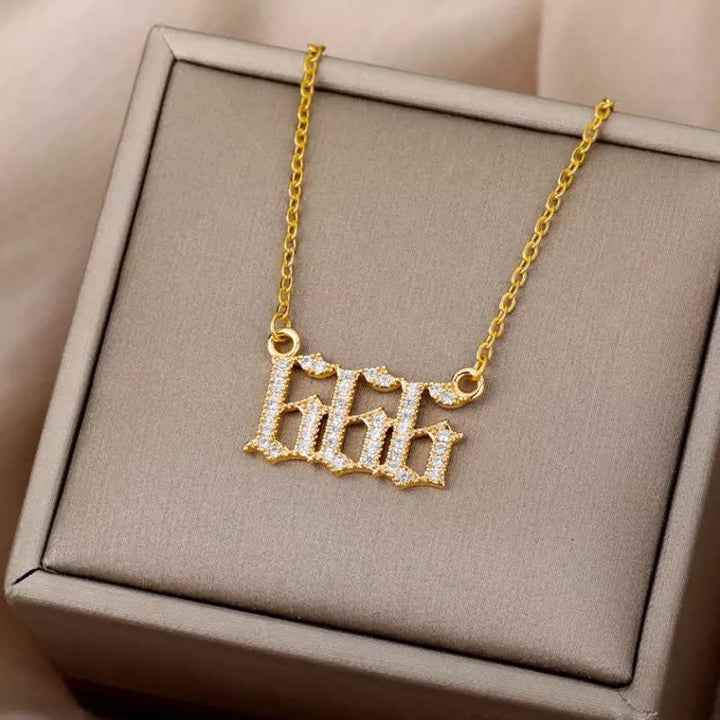 Goldene Halskette mit "666"-Anhänger, verziert mit Diamanten, auf beigem Schmuckkästchen.