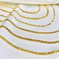 Goldene Halsketten auf weißem Stoff, Schmuck, Ketten, luxuriös, modisch, Accessoires.